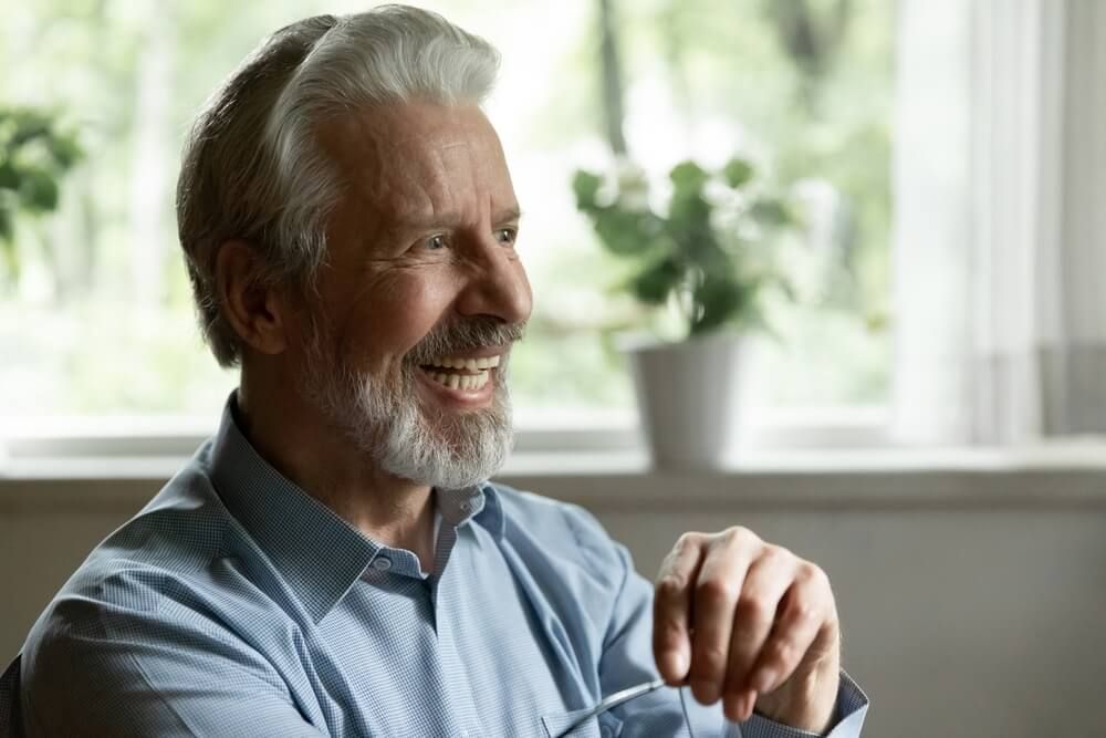 Happy old male dental clinic customer satisfied with good medical service healthy teeth modern implants.